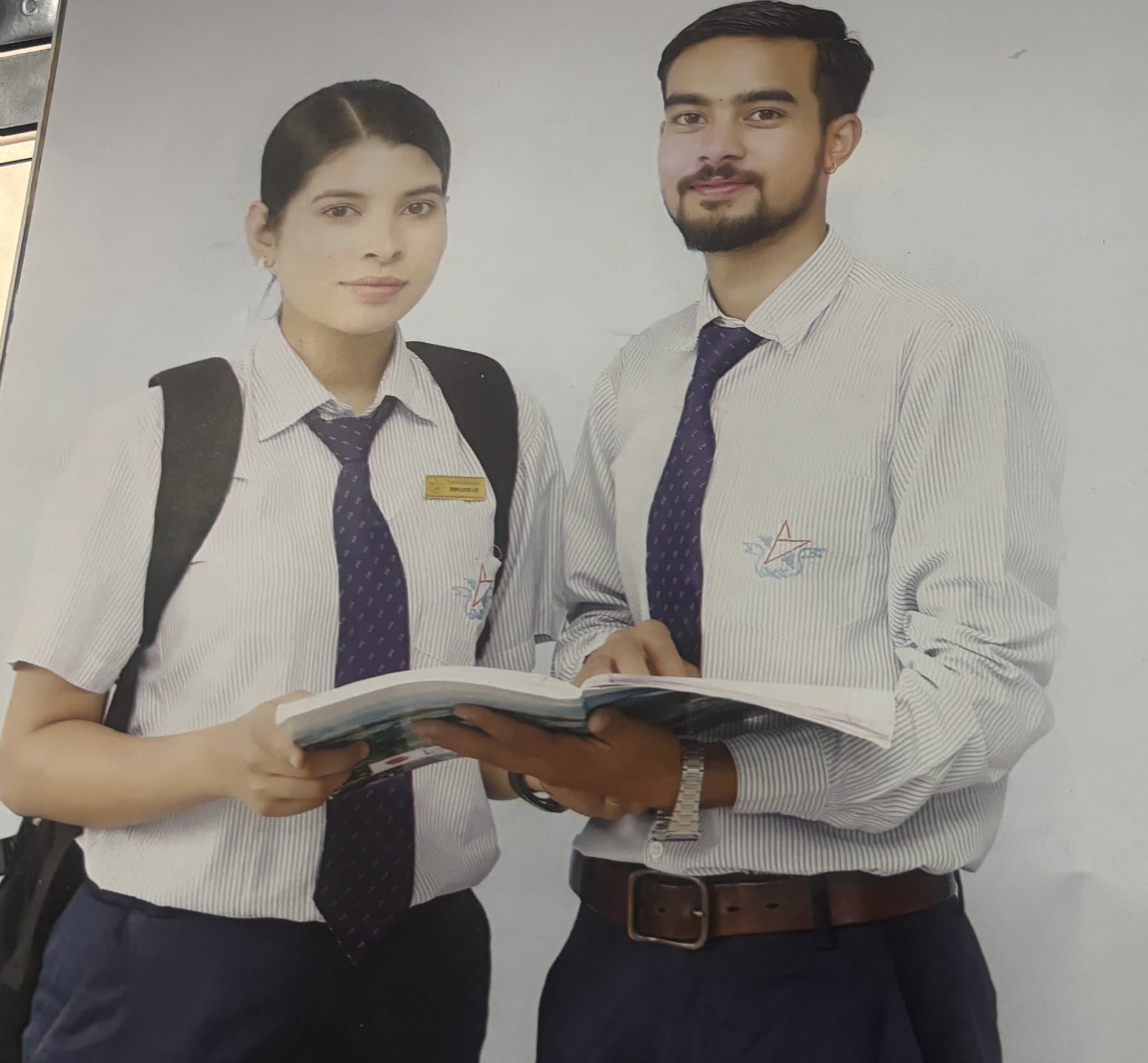 Two BBM students sharing a textbook in SWSC uniform