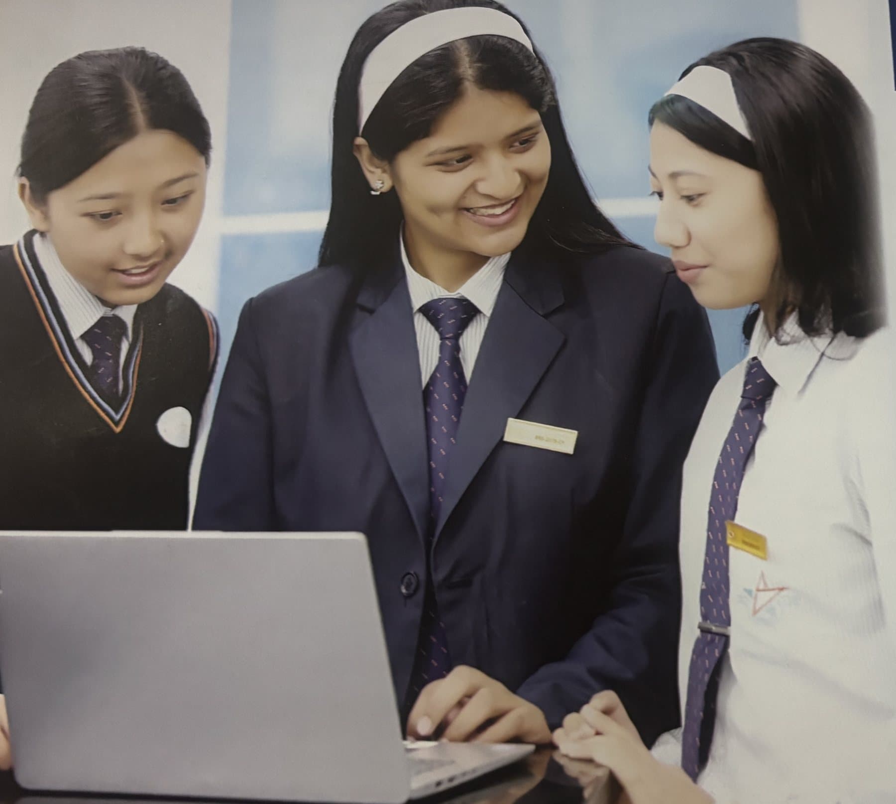 Three BBS students working together at a laptop
