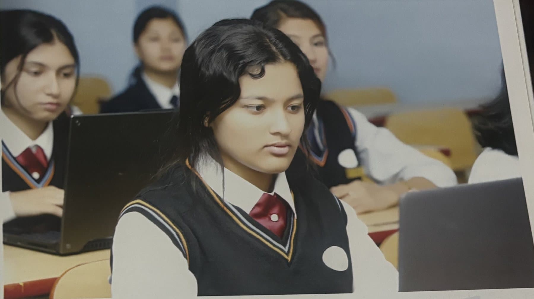 A student studying at a laptop in a classroom