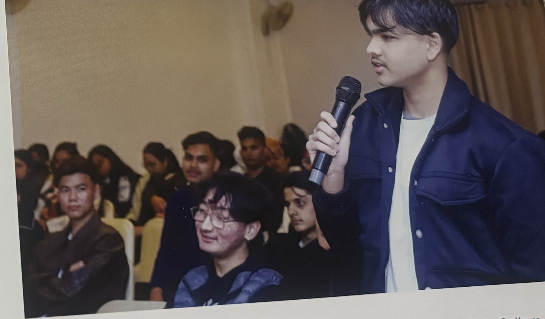 A student addressing a hall of classmates